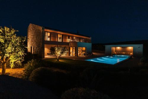 普利莫顿Villas Misto的一座晚上设有游泳池的房子