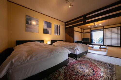 由布市汤布院里山茶风日式旅馆的一间带两张床的卧室和地毯