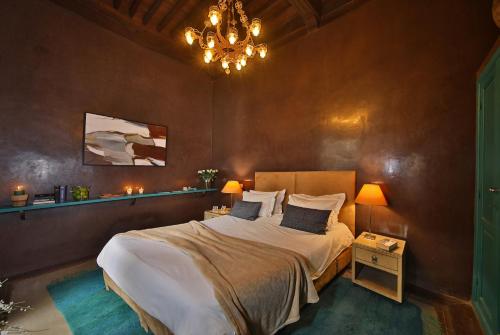 马拉喀什达尔万庭院旅馆的一间卧室配有一张大床和一个吊灯。