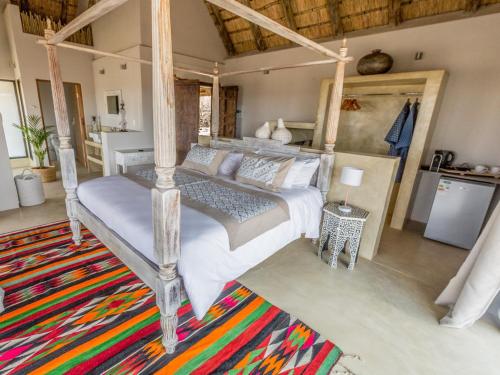 侯斯普瑞特The Wild Blue Lodge SAFARI & SPA的一间卧室配有一张床和地毯