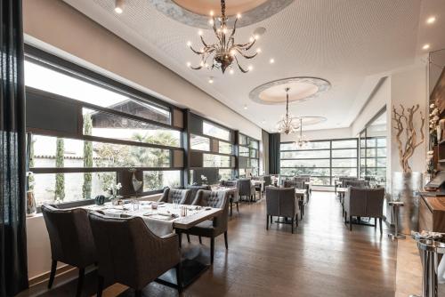 沃兰ALPIANA - green luxury Dolce Vita Hotel的一间带桌椅和吊灯的用餐室