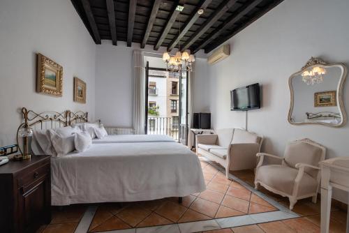 格拉纳达Hotel Rosa De oro的一间卧室配有一张床、两把椅子和一台电视