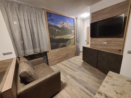 安达洛Al Toscana的带沙发和平面电视的客厅