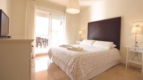 米哈斯Cozy Rentals Princess - Sun, Golf, Mountain的一间卧室设有一张床和一个大窗户