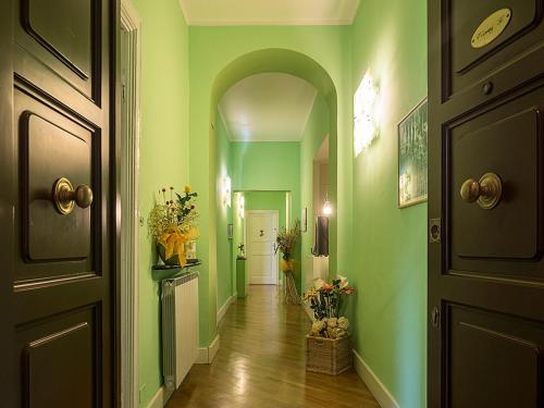 斯培西亚维亚尼住宅旅馆的走廊上设有绿色的墙壁和拱门