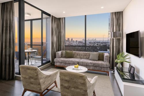 悉尼车士活美利通公寓式酒店的带沙发和大窗户的客厅