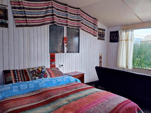 普诺Quechua lodge Titicaca的一间卧室设有一张床和一个窗口