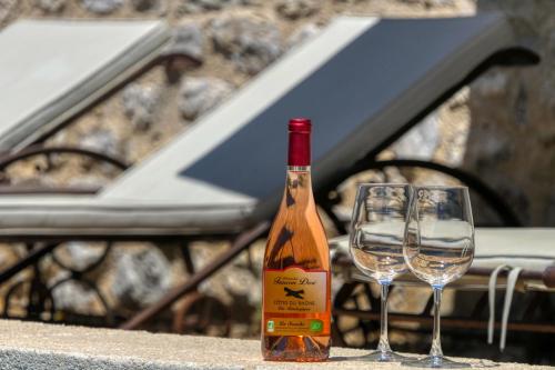EygaliersMas en Baronnies Provençales的桌子上放有一瓶葡萄酒和两杯酒