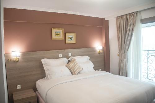 杜阿拉FAYA Hotel的卧室设有一张白色大床和一扇窗户。