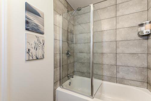 魁北克市Le Royale - Havre de paix的带淋浴和白色浴缸的浴室
