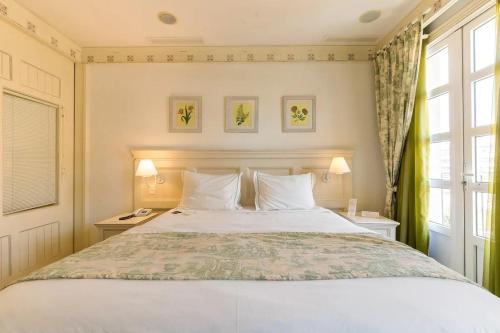 弗洛里亚诺波利斯Studio IL Campanario Villagio Resort的一间卧室设有一张大床和一个窗户。