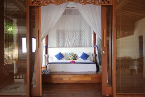 艾湄湾巴厘岛海滨别墅的一间卧室配有一张带天蓬的床