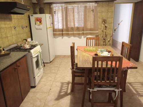 洛博斯El Descanso的厨房配有桌椅和冰箱。