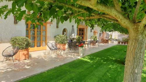 Pontlevoy圣艾洛住宿加早餐旅馆的一个带桌椅的庭院和一棵树
