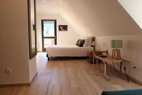 Villars-Colmars马塔贡餐厅酒店的一间卧室配有一张床和一张带台灯的桌子