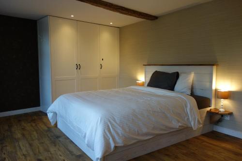 斯帕Gîte Citadin "Le Randon"的卧室配有一张白色大床和两盏灯。