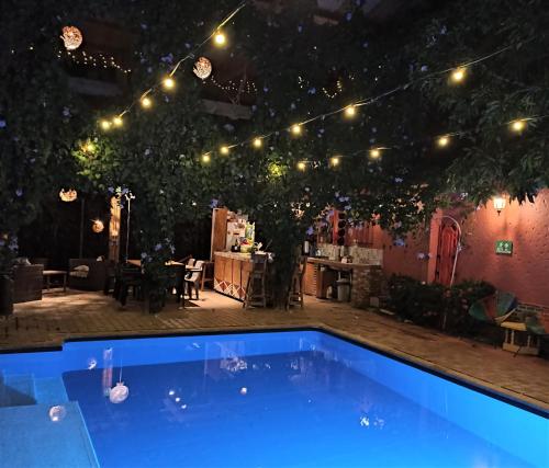 圣菲德安蒂奥基亚Hotel Casa de Verano - Solo adultos -的院子里的蓝色游泳池,灯光亮丽