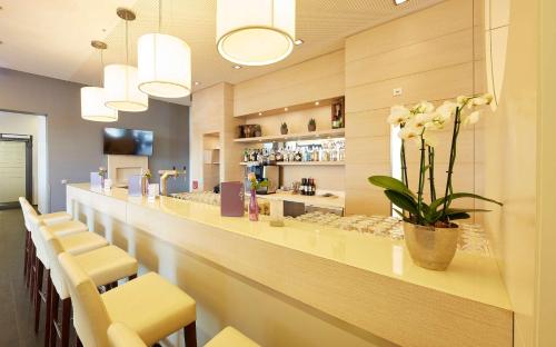 科布伦茨科布伦茨GHOTEL生活酒店的餐厅设有酒吧,酒吧内摆放着黄色椅子和鲜花