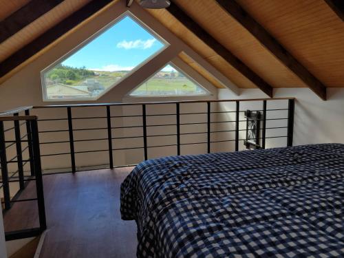 蓬塔阿雷纳斯Cabañas Pidén的一间卧室设有一张床和一个大窗户