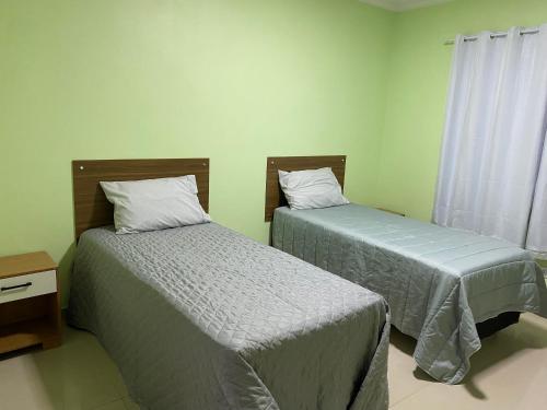 戈亚斯州上帕莱索Suítes Acolhedoras da Diva的小型客房 - 带2张床和窗户