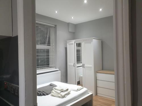 巴尔内特Lovely 1 bedroom flat High Barnet 3 mins away的白色的客房配有床和镜子
