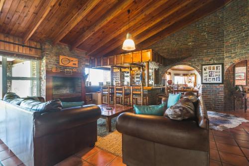 开普敦Melkbos Beach Lodge的客厅配有2张真皮沙发和壁炉