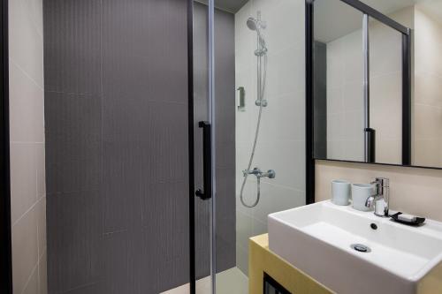 香港香港亚士厘名致公寓酒店的带淋浴、盥洗盆和镜子的浴室