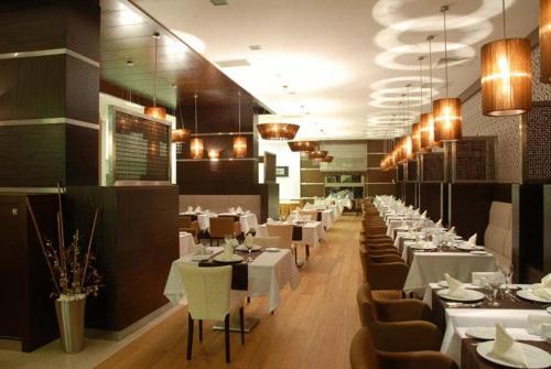 卡赫拉曼马什拉Ramada Plaza By Wyndham Kahramanmaras的一间设有白色桌椅的用餐室