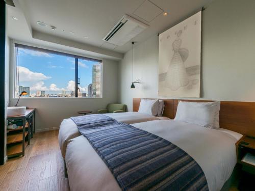 东京艾比苏霍利克酒店的一间卧室设有一张大床和一个大窗户