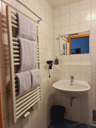 巴特霍夫加施泰因Frühstückspension Klein und Fein的白色的浴室设有水槽和毛巾。