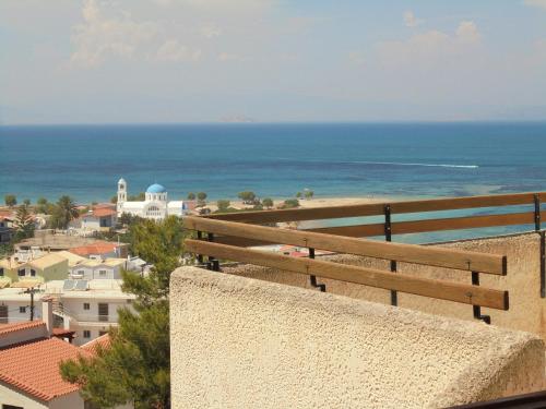 斯卡拉阿基斯提岛梦幻酒店的坐在墙上的长凳上,望着大海