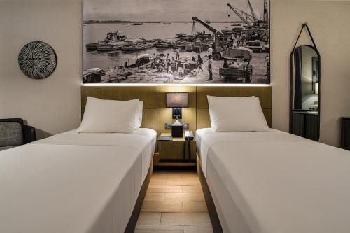 杜阿拉K Hotel Douala的两张睡床彼此相邻,位于一个房间里