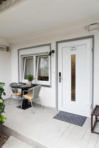 达姆施塔特Apartment-EG-09的庭院的白色门,配有桌椅