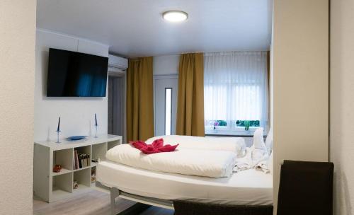 达姆施塔特Apartment-EG-09的卧室配有白色床,上面有红色的弓