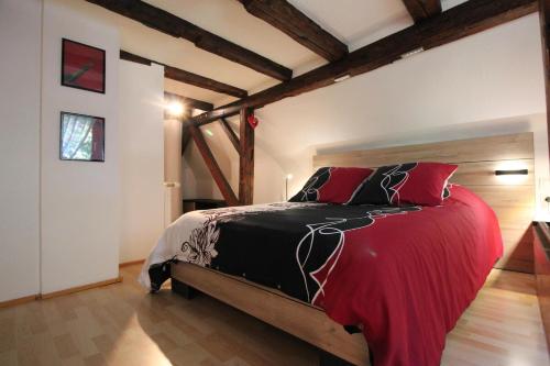 鲁法克Gîte de la Liberté的一间卧室配有一张带红色枕头的大床