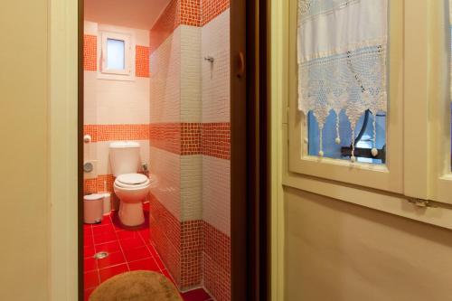 雅典Psyri Neoclassical House with Yard的一间铺有红色瓷砖的小浴室,设有卫生间