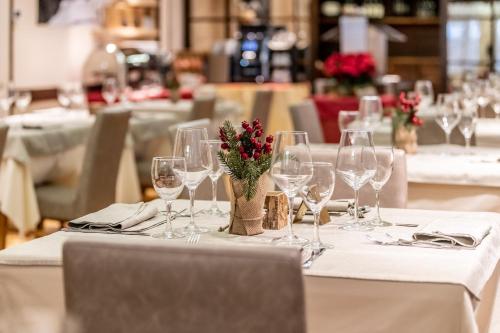 摩德纳迪-坎皮格里奥伊塔洛酒店的一张桌子,上面放着酒杯和鲜花
