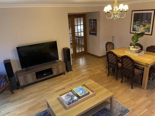 德里门Foxglove Cottages的客厅配有电视和桌椅