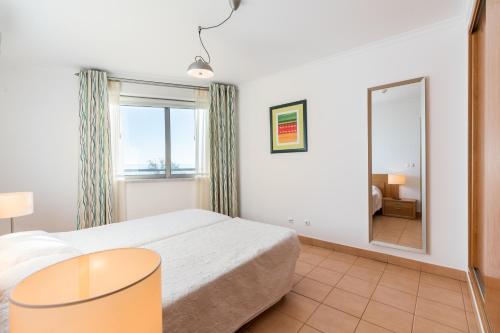 蒙蒂戈杜La Francesa Algarve的一间卧室配有一张床和一面大镜子