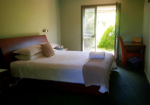 里士满Red Brier Cottage Accommodation的卧室配有一张大白色床和窗户