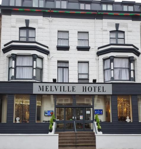 布莱克浦The Melville Hotel - Central Location的白色的建筑,上面有梅尔维尔酒店的标志