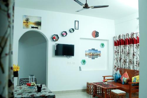瓦亚纳德Bethel Service Villa, Mananthavady, Wayanad的客厅配有沙发和墙上的电视