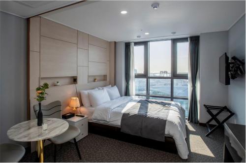 釜山Griffinbay Hotel的一间卧室设有一张床和一个大窗户