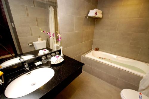 芽庄亚洲天堂酒店的浴室配有盥洗盆、卫生间和浴缸。