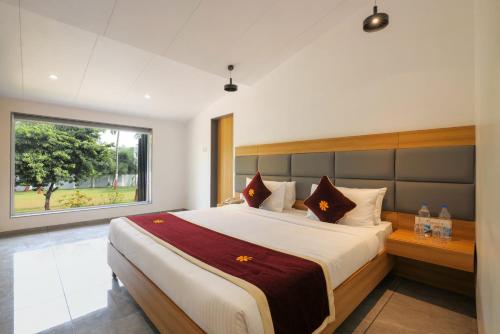 达曼Gold Beach Villa的一间卧室设有一张大床和一个窗户。