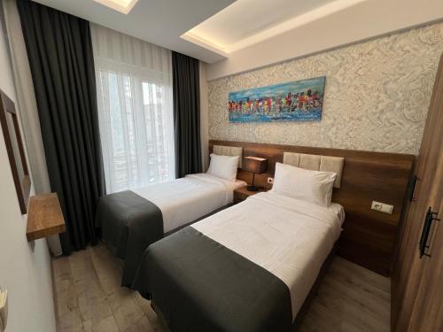 MelikgaziPRIME INN CITY的酒店客房设有两张床和窗户。