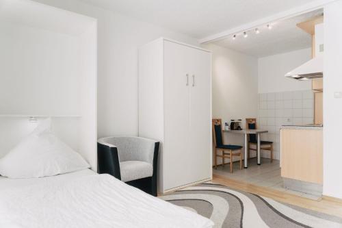 达姆施塔特Apartment-EG-05的一间白色卧室,配有床和厨房