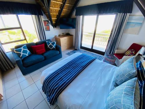 圣弗朗西斯湾Shalom-self catering apartment的一间卧室配有蓝色的床和沙发