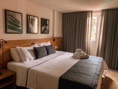 伊泰帕瓦Apart-hotel Granja Brasil Itaipava的一间卧室配有一张大床,上面有泰迪熊