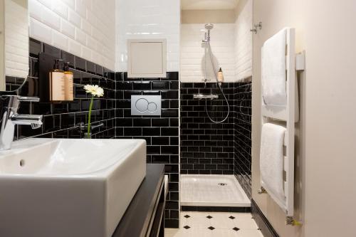 里蒙纽耶Ours Blanc Hotel & Spa的黑白浴室设有水槽和浴缸。
